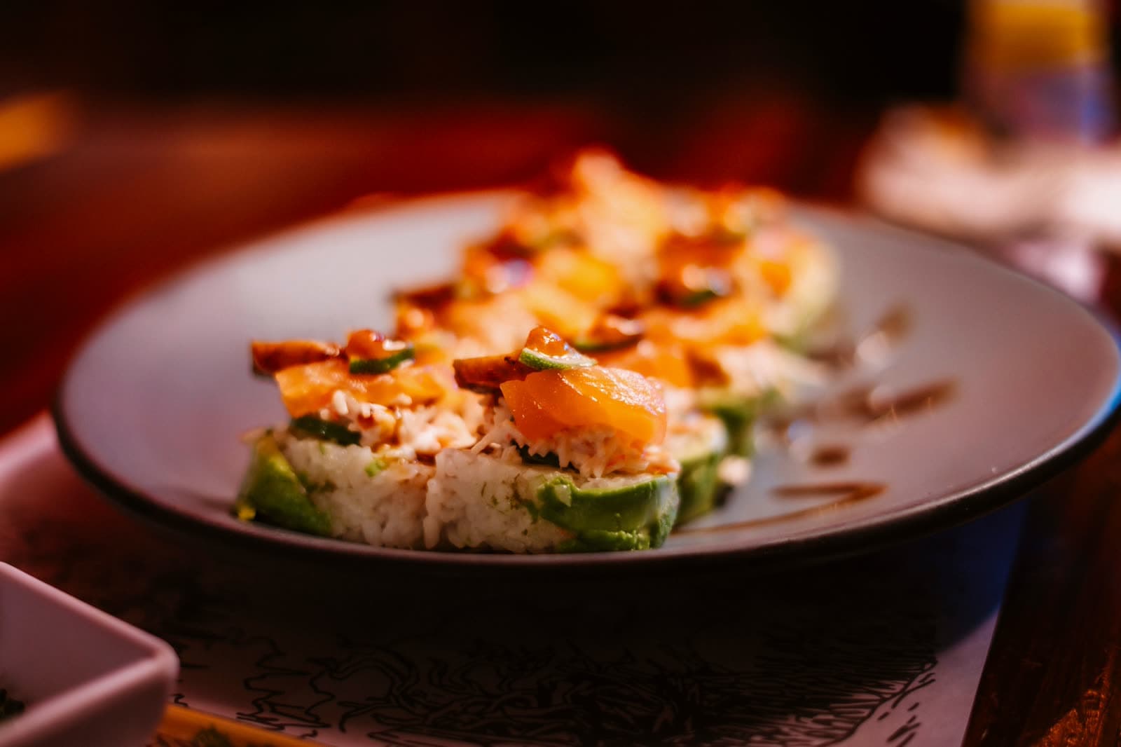 A bowl of salmon, avocado and rice, plated for the table.