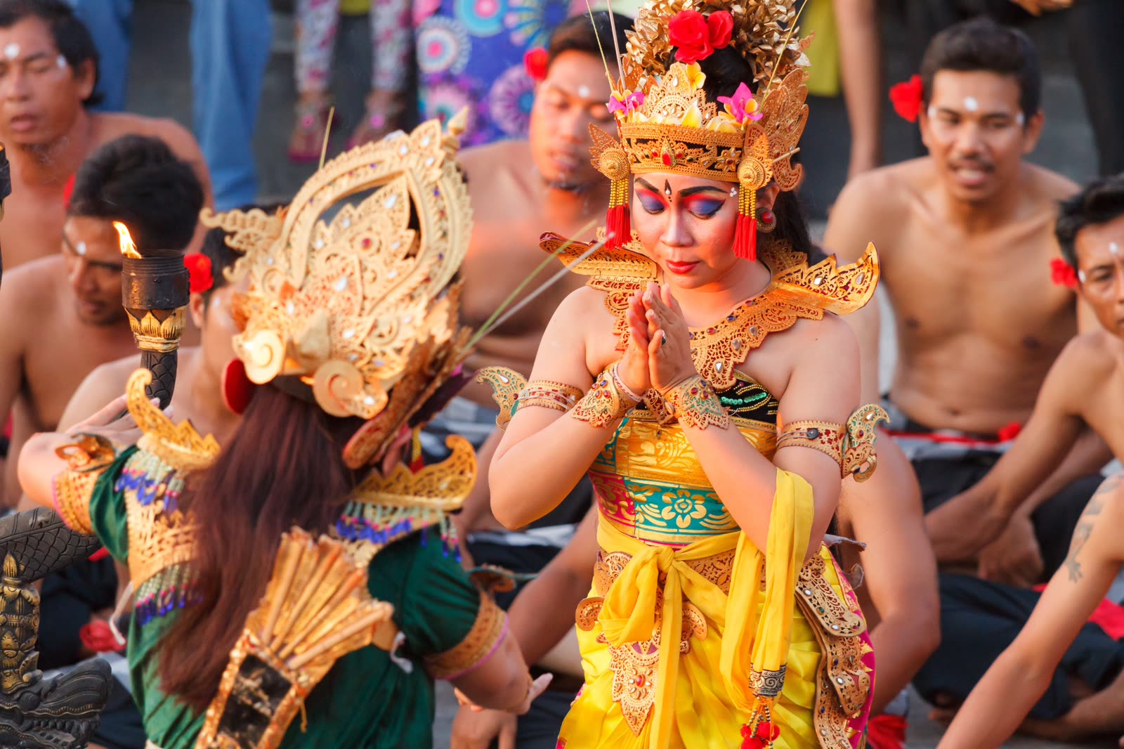 Balinese dancers in gilded headdresses performing at a temple ceremony.