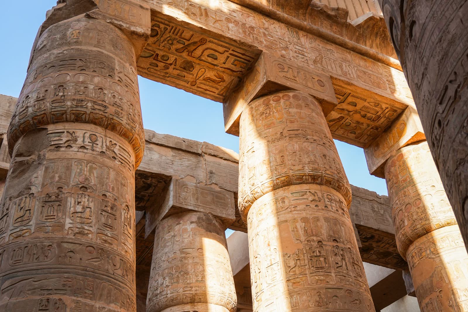 The carved hypostyle columns of Karnak Temple rising towards the architrave.