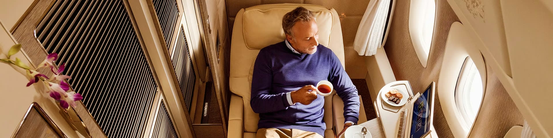 A traveller relaxing in an Emirates First Class suite