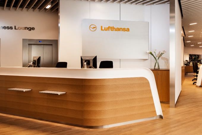 The reception desk of a Lufthansa business lounge, with the Senator Lounge beyond.
